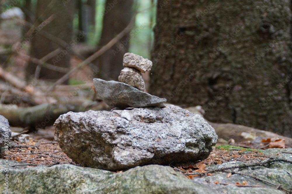 small stones stacked in the shape of a tower in a fairy forest in Franconia Germany on a Sunny summer day small stones stacked in the shape of a tower in a fairy forest in Franconia Germany on a Sunny summer day