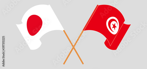 Crossed and waving flags of Japan and Tunisia