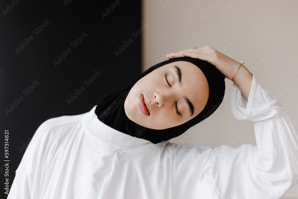 Ethnic woman in traditional clothes stretching neck Ethnic woman in traditional clothes stretching neck