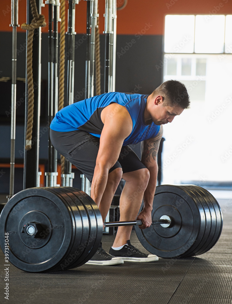 Caucasian man lifting weights in gym Caucasian man lifting weights in gym