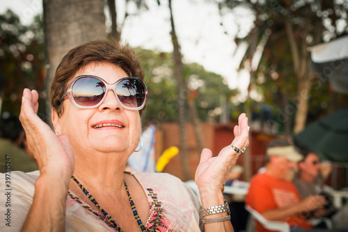Older woman clapping outdoors photo