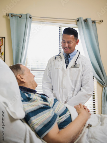 Doctor talking to patient in hospital bed photo