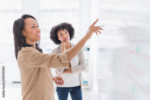 African American businesswomen at whiteboard in office photo