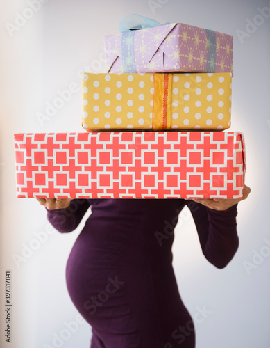 Pregnant Caucasian woman holding wrapped gifts