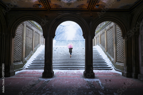 Asian woman walking up steps into snow