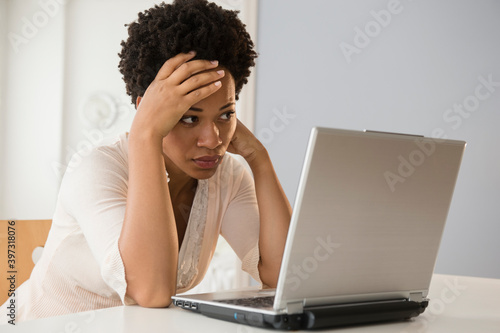 Frustrated Black businesswoman using laptop