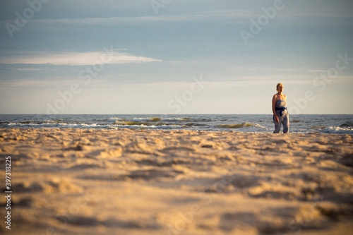 Young beautiful woman walking on the sand beach