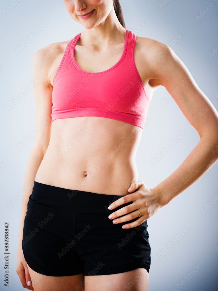Caucasian woman with bare stomach wearing sports clothing Caucasian woman with bare stomach wearing sports clothing