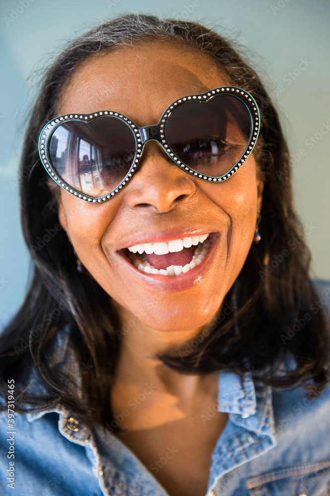 Mixed race woman wearing heart-shaped sunglasses Mixed race woman wearing heart-shaped sunglasses