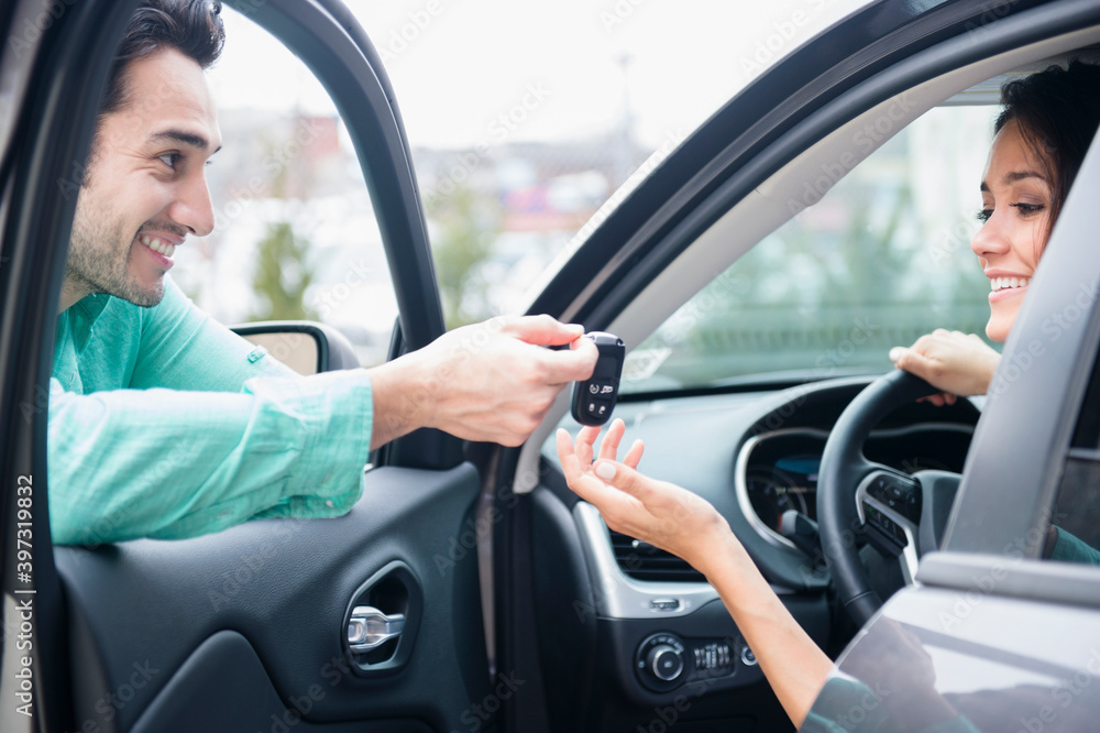 Man giving girlfriend keys to car Man giving girlfriend keys to car