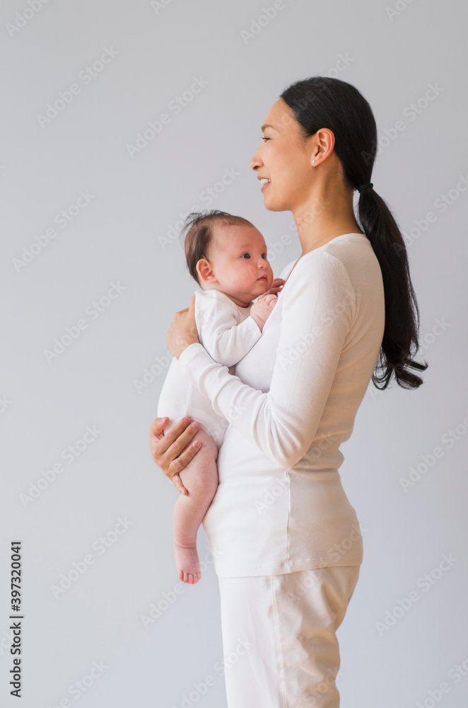 Profile of Asian mother holding baby Profile of Asian mother holding baby