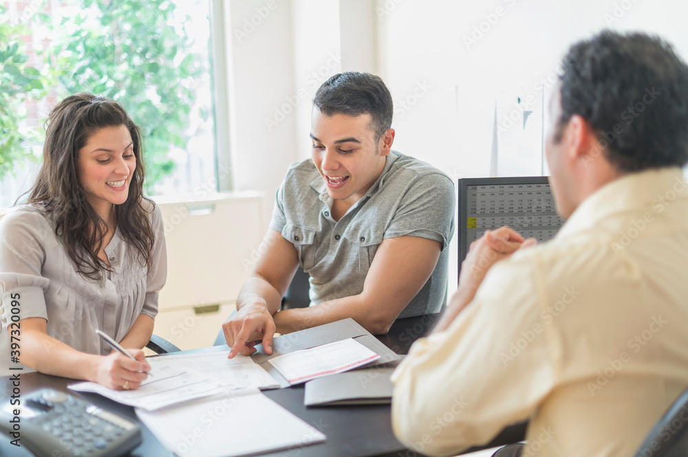 Hispanic businessman talking to clients in office Hispanic businessman talking to clients in office