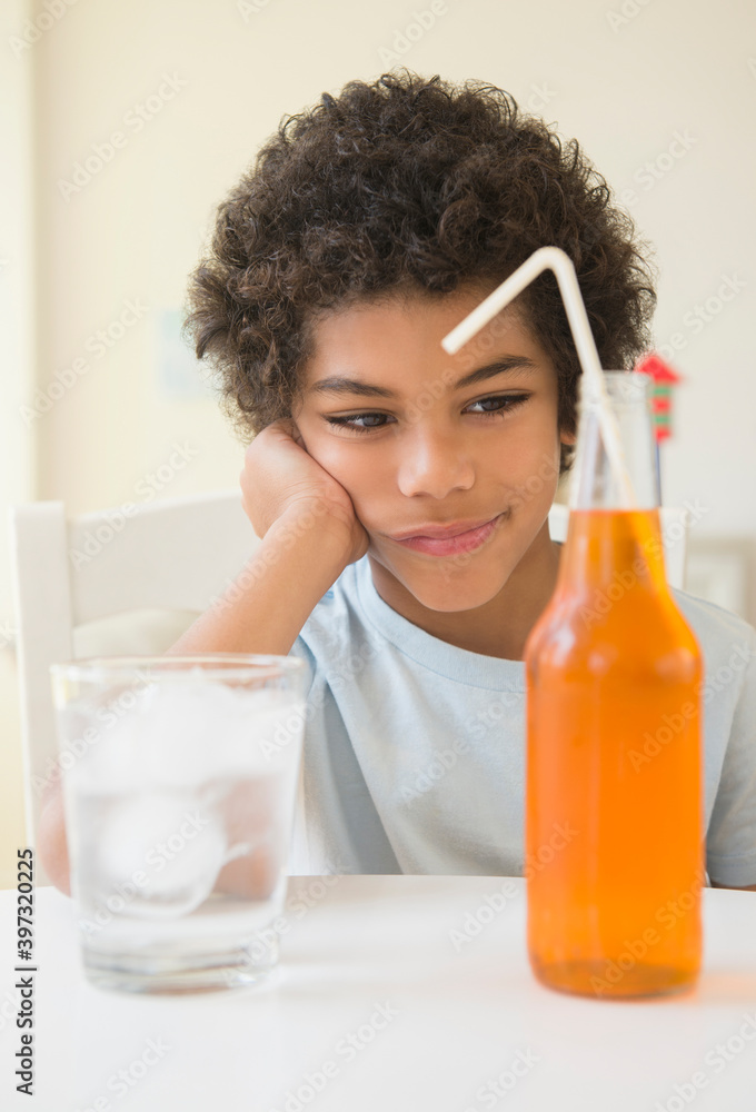 Mixed race boy choosing between soda and water Mixed race boy choosing between soda and water