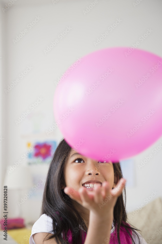 Smiling Vietnamese girl playing with pink balloon Smiling Vietnamese girl playing with pink balloon