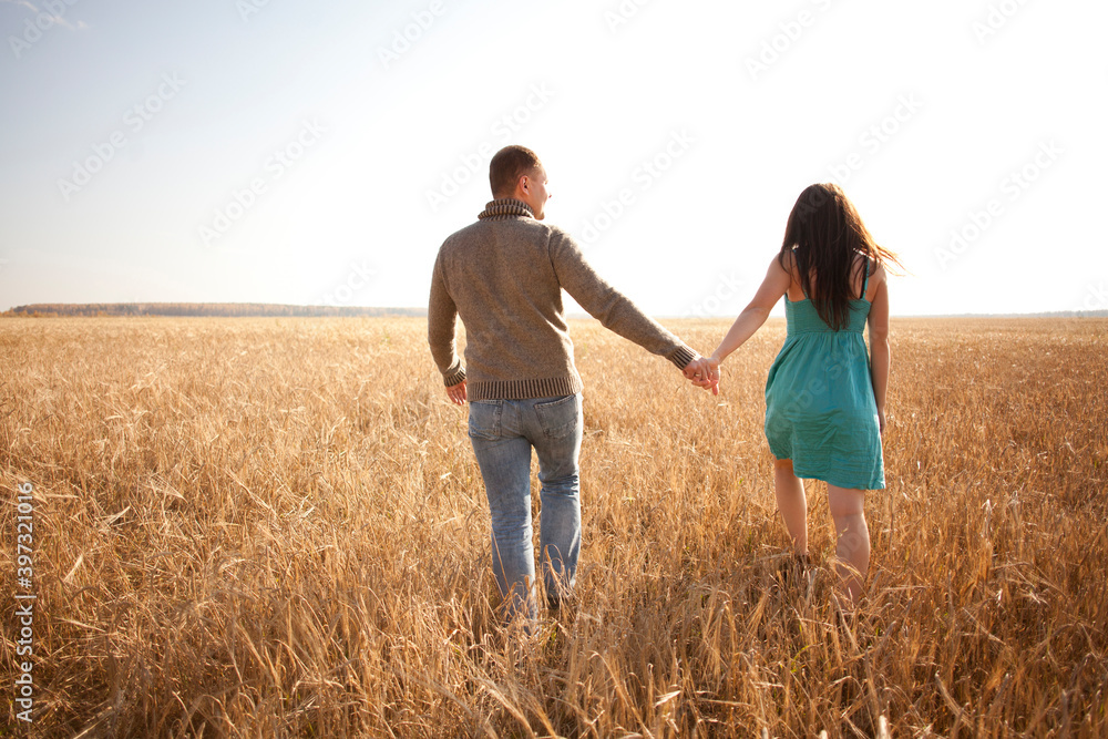Caucasian couple holding hands in rural field Caucasian couple holding hands in rural field