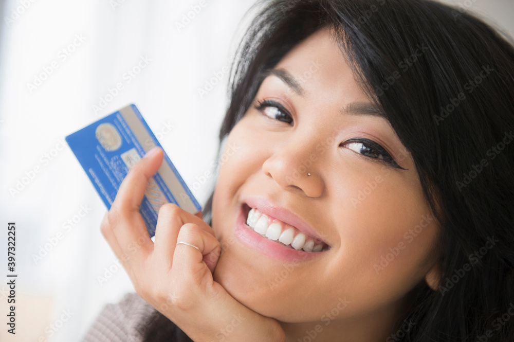 Smiling Pacific Islander woman holding credit card Smiling Pacific Islander woman holding credit card