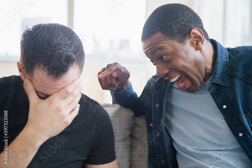 Close up of man teasing friend on sofa