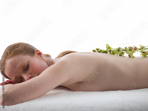 Caucasian woman having massage with flowers photo