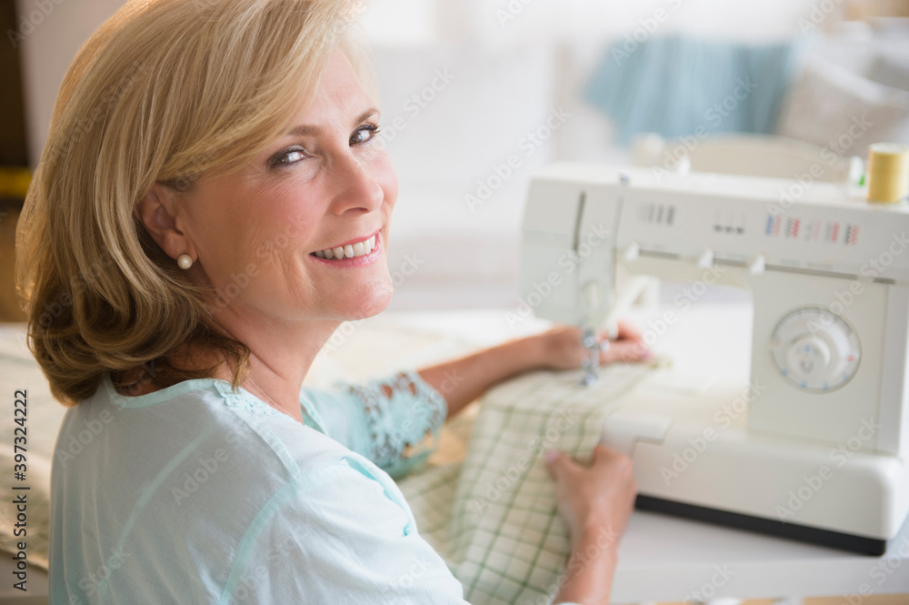 Caucasian woman using sewing machine Caucasian woman using sewing machine