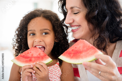 Mother and daughter eating watermelon