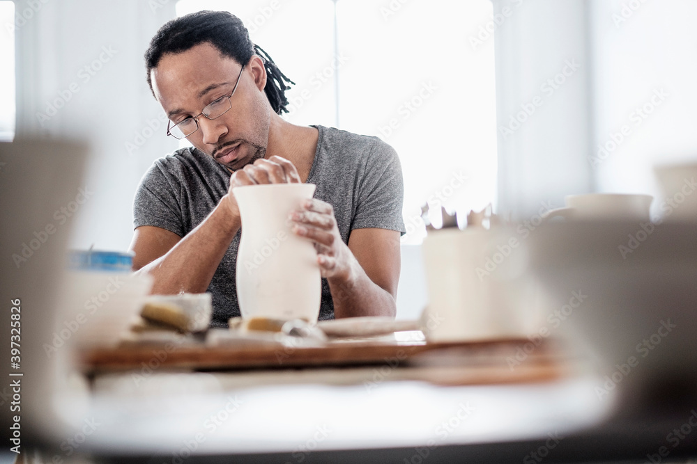 Black artist shaping ceramic vase in studio Black artist shaping ceramic vase in studio