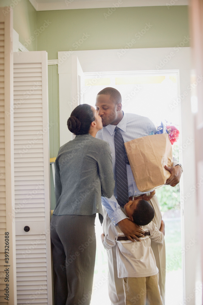 © Annika Erickson/Blend Images - African father with groceries greeting family © Annika Erickson/Blend Images - African father with groceries greeting family