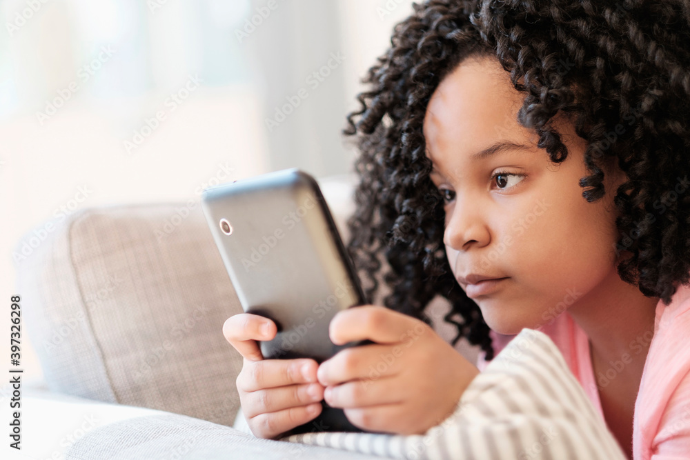 African American girl using cell phone on sofa African American girl using cell phone on sofa