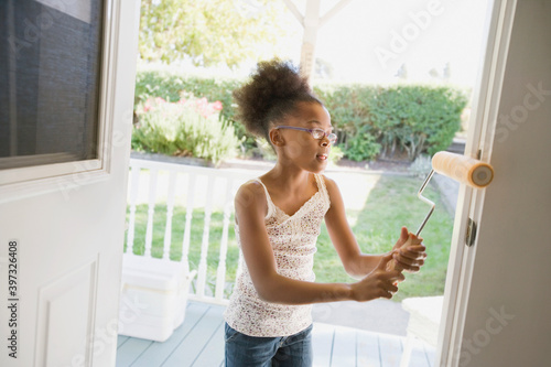 Mixed race girl painting doorway