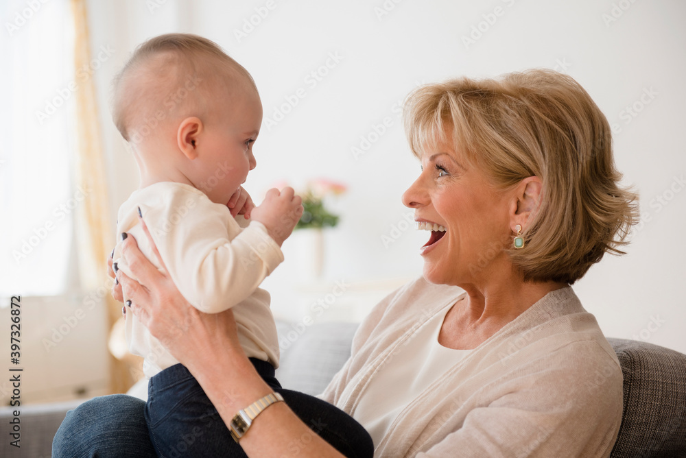 Caucasian grandmother making a face at baby granddaughter Caucasian grandmother making a face at baby granddaughter