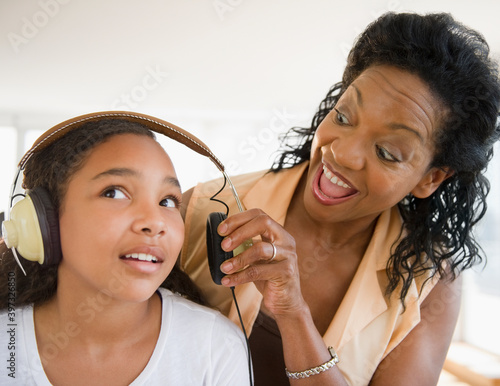 Mother shouting at daughter listening to headphones photo