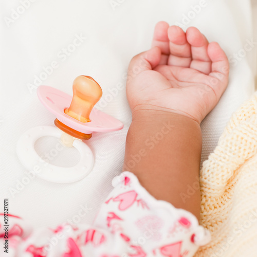 Hand of African baby and pacifier photo