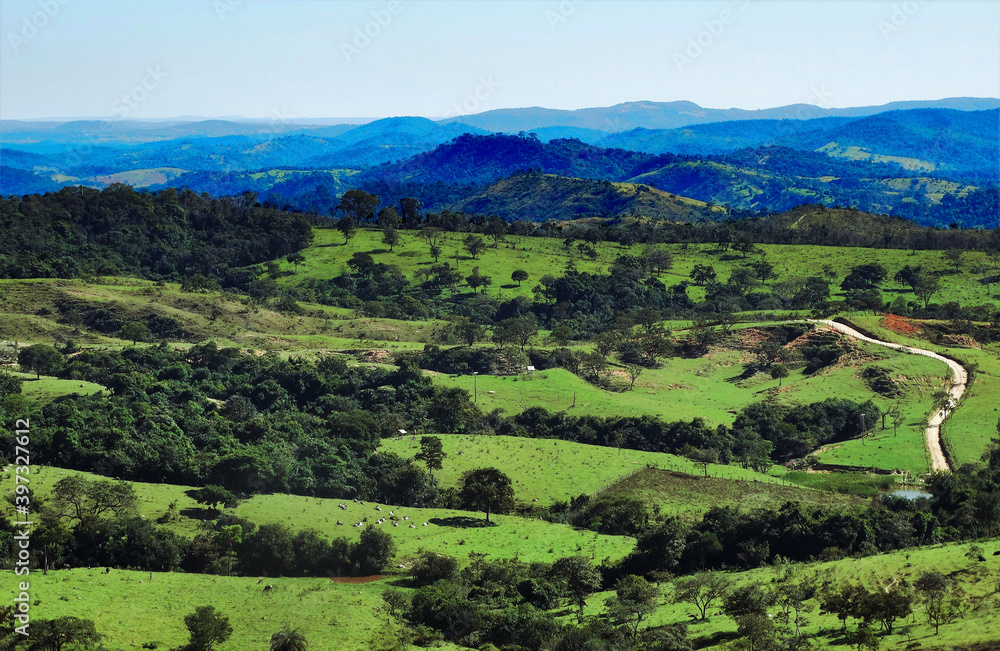 Linda vista de cima de montanha em final de tarde ensolarada, de fazenda situada na região de Esmeraldas, Minas Gerais, Brasil.