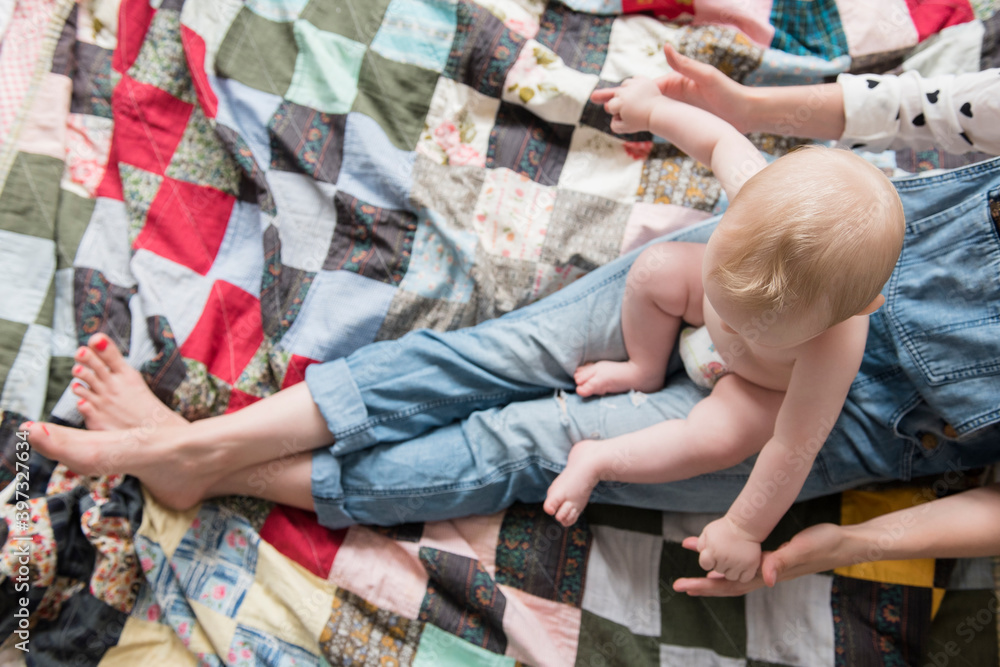 Caucasian mother sitting on blanket with baby son on lap Caucasian mother sitting on blanket with baby son on lap