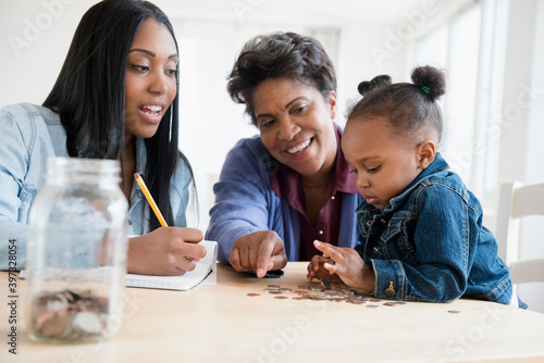 Black multi-generation family counting coins photo