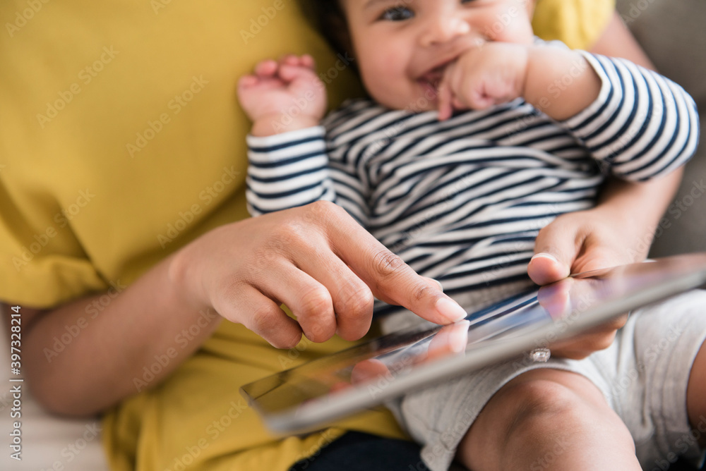 Mother holding baby son using digital tablet Mother holding baby son using digital tablet