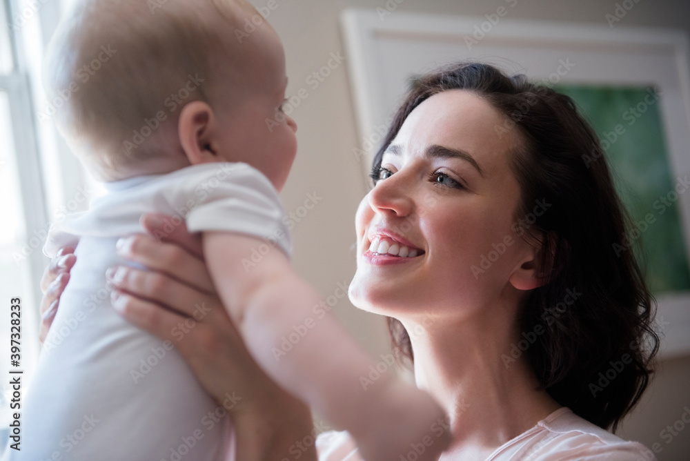 Caucasian mother holding baby son face to face Caucasian mother holding baby son face to face