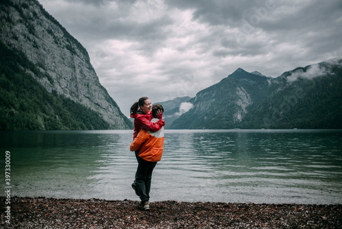 Caucasian man hugging near mountain lake photo