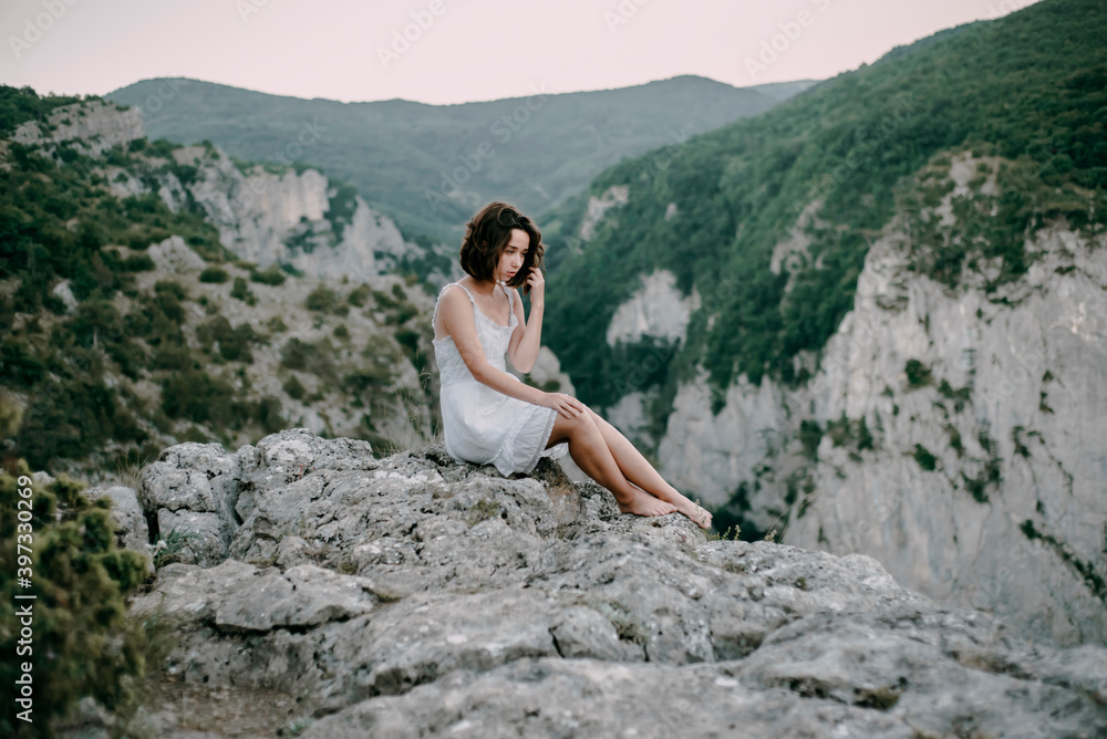 Pensive Caucasian woman sitting on mountain Pensive Caucasian woman sitting on mountain