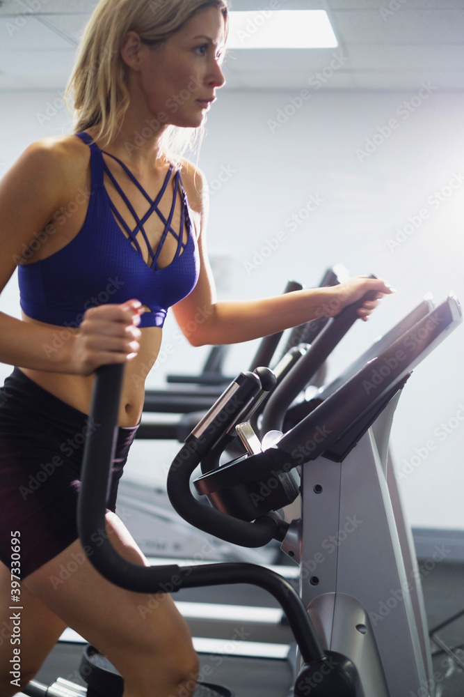 Mixed Race woman using elliptical machine Mixed Race woman using elliptical machine