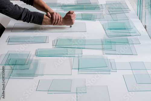 Piles of glass and glass cutter on white table photo