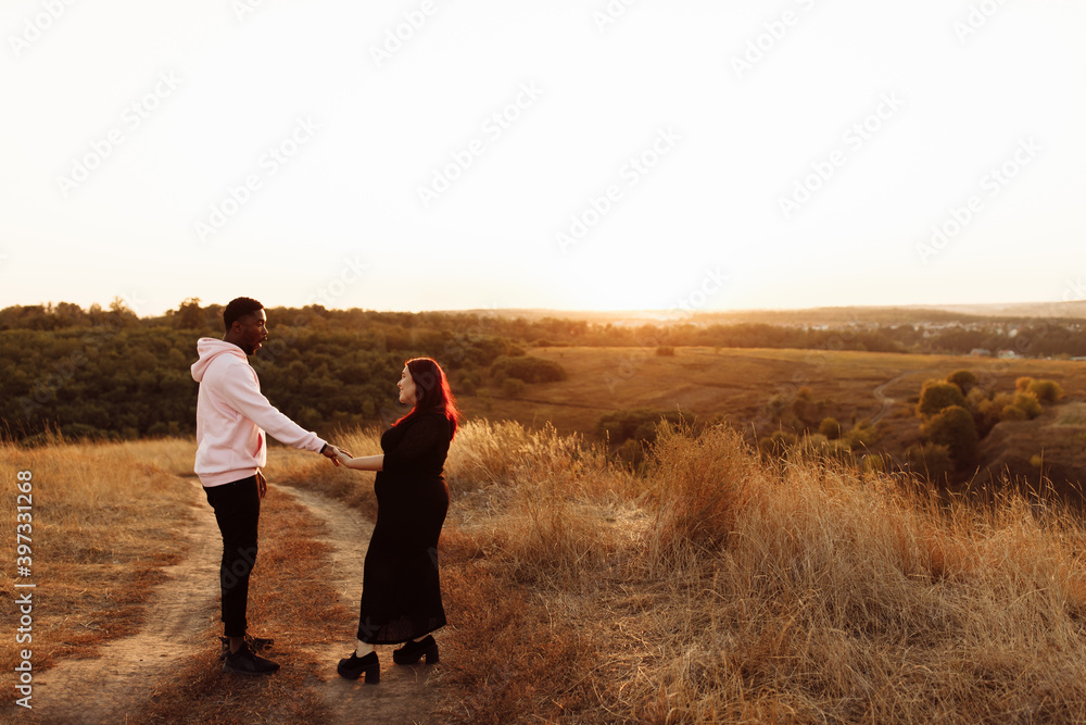 Beautiful couple walking at the field, attractive husband holding hands adorable wife, overjoyed woman smiling, happy family spend time together, weekends outdoors concept