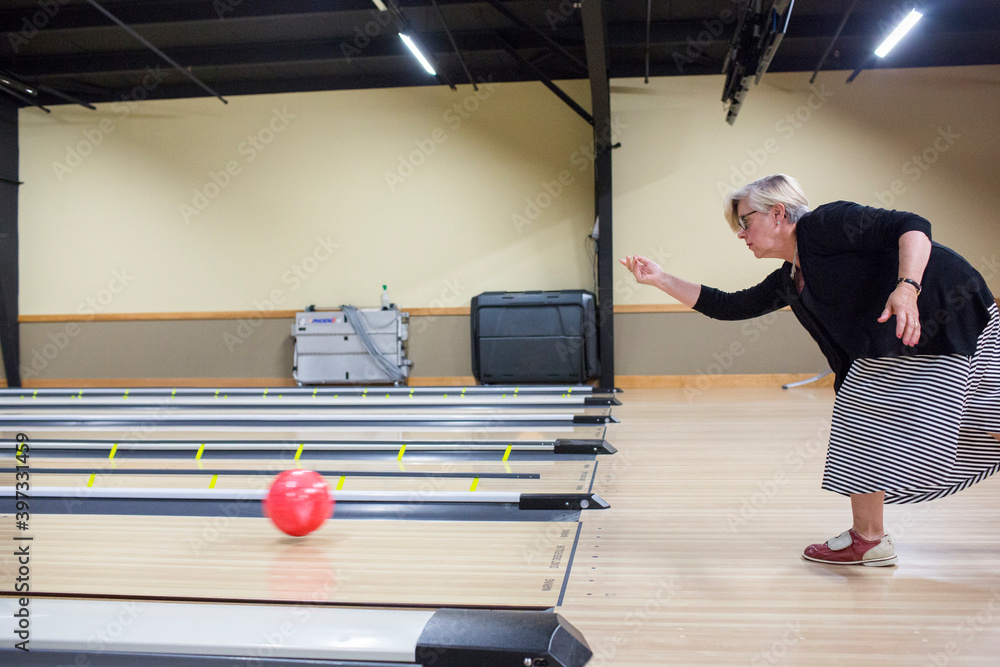 Caucasian woman releasing bowling ball in lane Stock Photo Adobe Stock