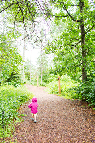 Caucasian girl walking on path in forest photo