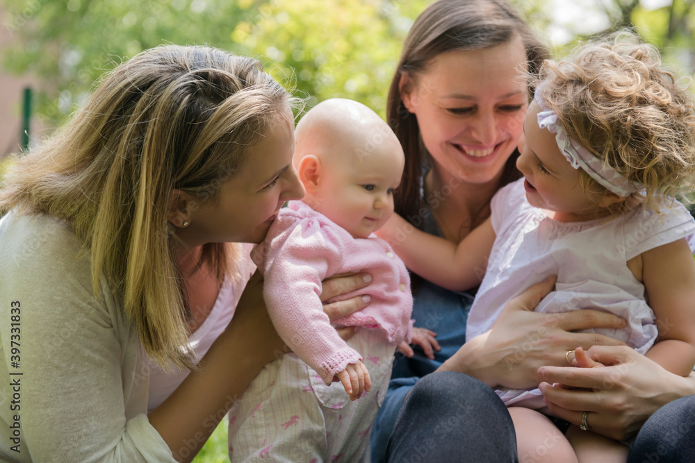 Caucasian mothers and daughters playing in park Caucasian mothers and daughters playing in park