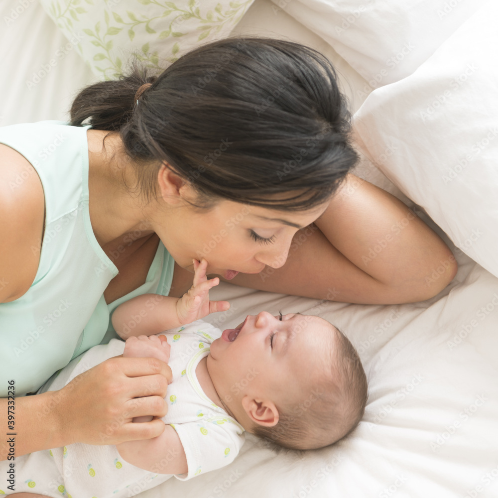 Mother and baby (2-5 months) lying on bed Mother and baby (2-5 months) lying on bed