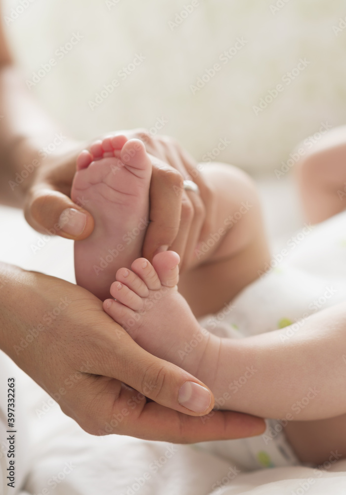 Mother holding feet of baby boy (2-5 months) Mother holding feet of baby boy (2-5 months)