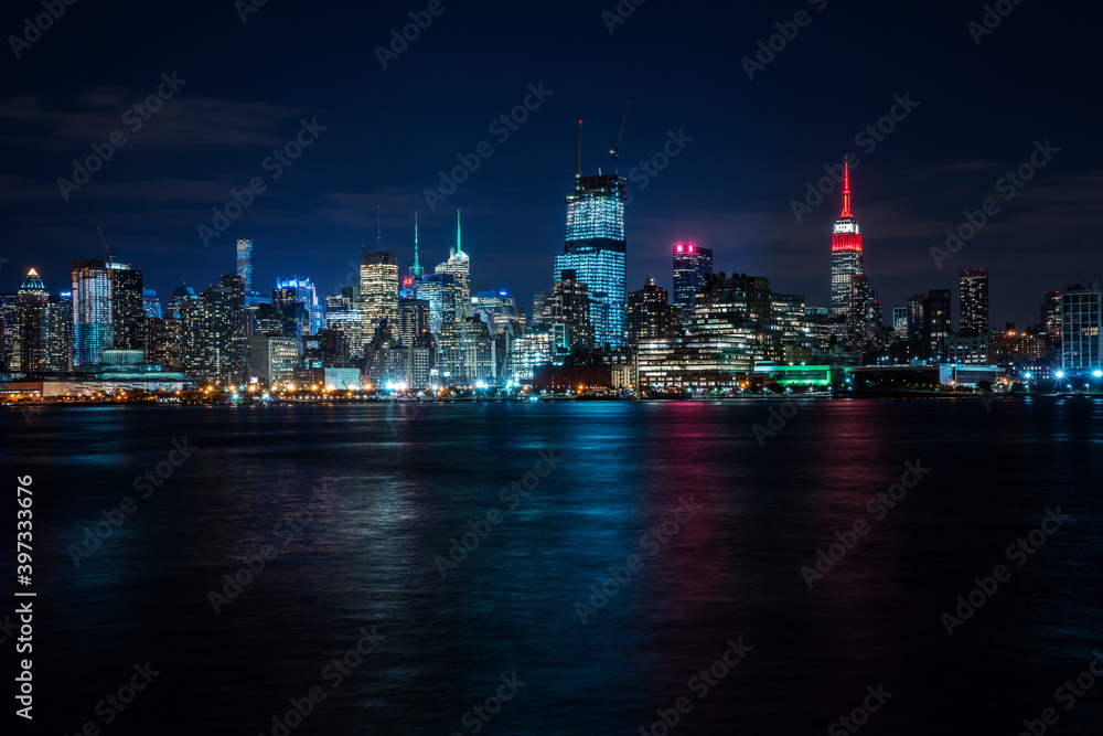 Illuminated cityscape reflecting in river Illuminated cityscape reflecting in river