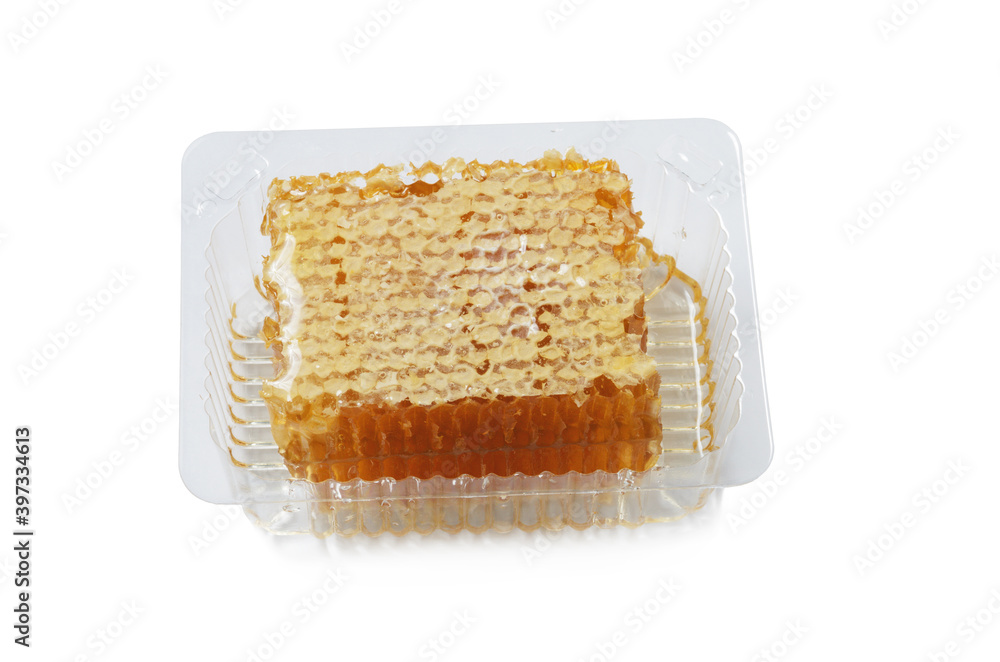 Honey in a honeycomb Packed in a plastic disposable container isolated on a white background Honey in a honeycomb Packed in a plastic disposable container isolated on a white background