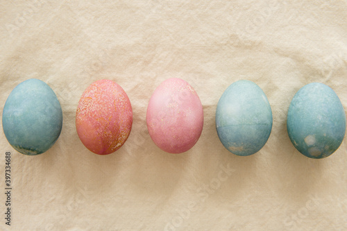 Dyed Easter eggs in a row on beige photo