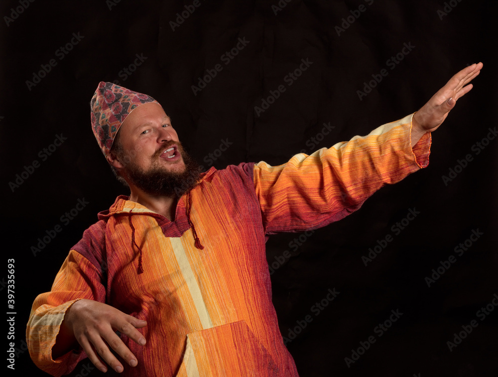 Joyful bearded man in bright orange shirt dancing